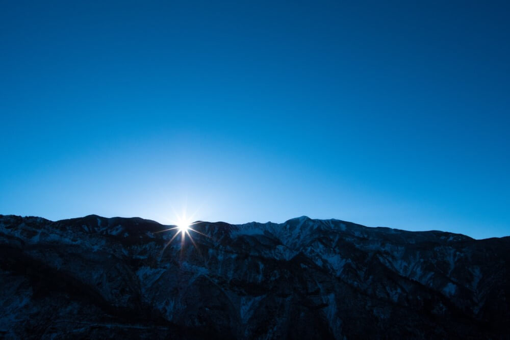 sunrise appearing from over mountains in Japanese national park